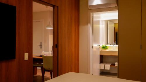 a room with a bathroom with a sink and a mirror at Soho Plaza Hotel in Brasília
