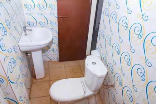 a bathroom with a toilet and a sink at Hotel Résidence Les Racines in Pira