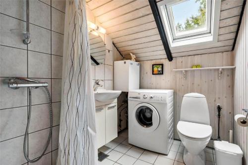 a small bathroom with a washing machine and a sink at 0161-Romo-Ejnar-Mikkelsensvej-4 in Høm