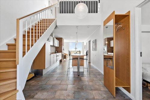 a room with a staircase and a kitchen with a table at 1170-Romo-Gulirisvej-170 in Høm