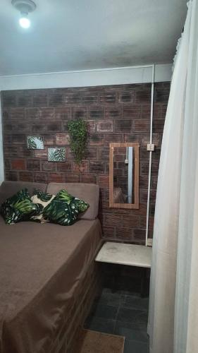 a room with a couch and a brick wall at Só Alegria in Paulista