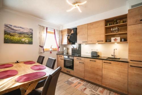 a kitchen with a wooden table and a dining room at Apartment Morgensonne in Piesendorf