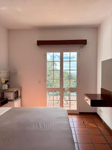 a bedroom with a bed and a large window at Habitación con terraza privada y vista a Funchal in Estrela
