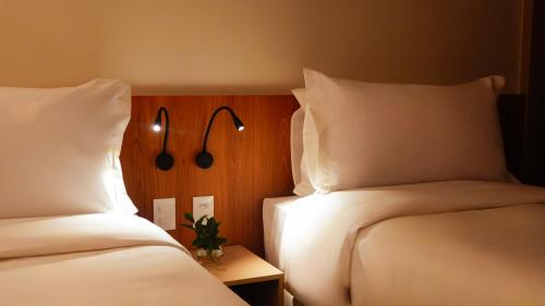 a hotel room with two beds with white pillows at Soho Plaza Hotel in Brasília