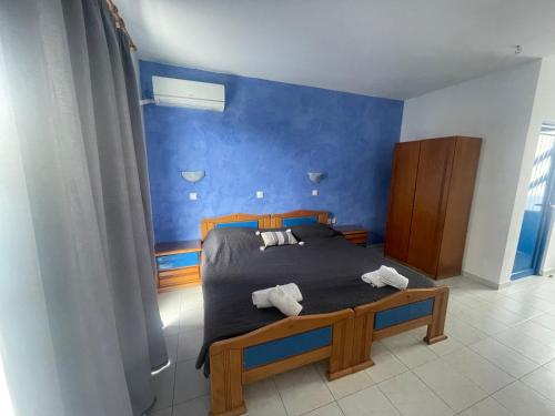a bedroom with a bed with a blue wall at Dodekanisos Studios in Faliraki