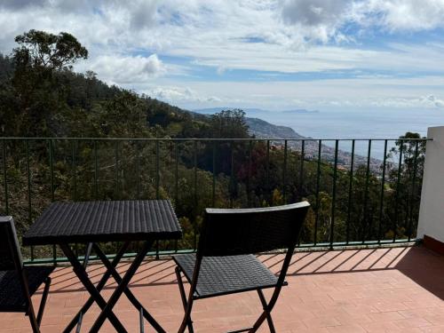 a table and chairs on a balcony with a view at Habitación con terraza privada y vista a Funchal in Estrela