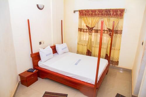 a small bedroom with a bed and a window at Hotel Résidence Les Racines in Pira
