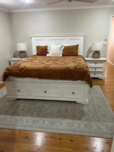 a bedroom with a large bed with two night stands at Lamington Cottage in The Range