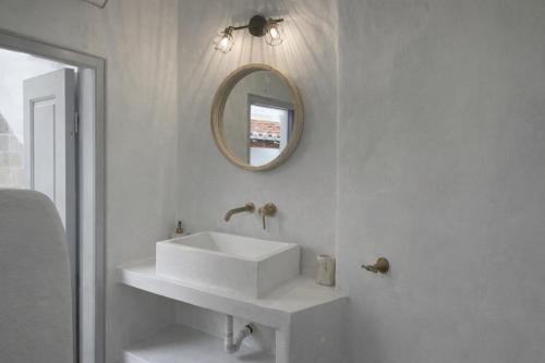 a white bathroom with a sink and a mirror at Lemon House in Hydra