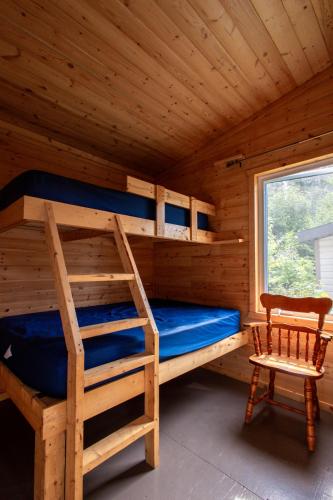 a bedroom with bunk beds in a log cabin at Espace des Grands-Ducs - Domaine de Lacs et de forêt in Sacré-Coeur-Saguenay