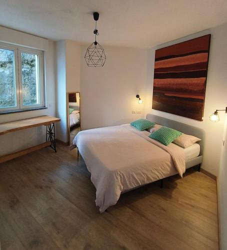 a bedroom with a bed and a desk and window at Kaspers home lake Como in Blevio