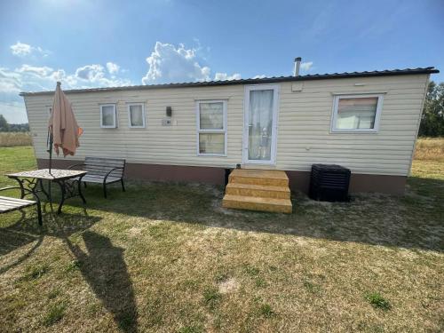 a mobile home with a table and a patio at FarmaKolonia in Jamielnik