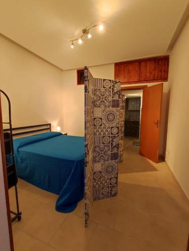 a bedroom with a bed and a blue bedspread at Lolli Station House in Palermo