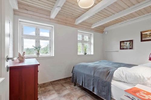 a bedroom with a bed and two windows at 0123-Romo-Ivigtut-9 in Høm