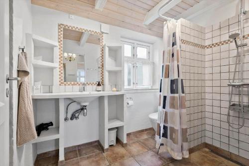 a bathroom with a sink and a toilet and a mirror at 0123-Romo-Ivigtut-9 in Høm
