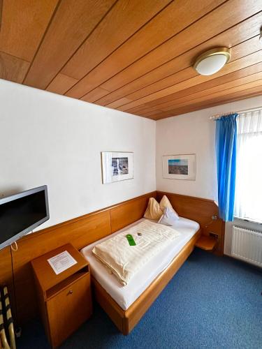 a small room with a bed and a television at Hotel Haus Margarete am Meer in Norderney