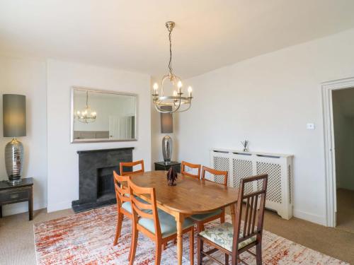 a dining room with a table and chairs and a fireplace at 7 Athol Terrace in Dover