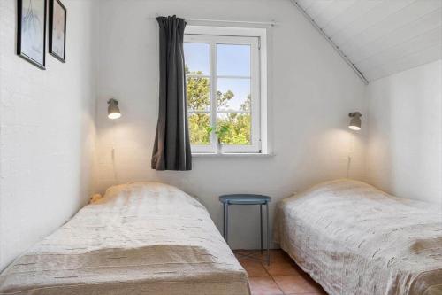 two beds in a room with a window at 2008-Romo-Froidal-10 in Høm