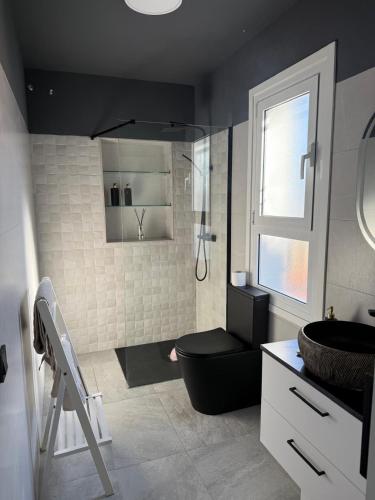 a bathroom with a black toilet and a sink at Evian Cala in Miami Platja