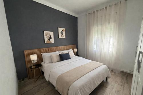 a bedroom with a large bed and a gray wall at Evian Cala in Miami Platja