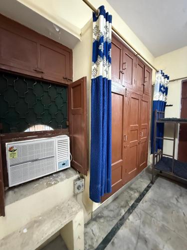 a room with a heater and blue curtains at Nook Coliving Male Only in Lucknow