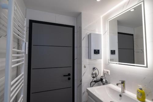 a white bathroom with a sink and a mirror at Apartment Deichblick in Büsum