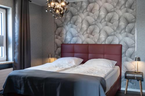 a bedroom with a large bed with a red headboard at Apartment Deichblick in Büsum