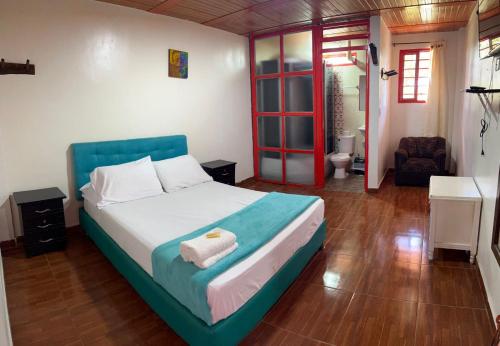 a bedroom with a large bed with a blue headboard at Finca Tradicional La Rochela in Montenegro