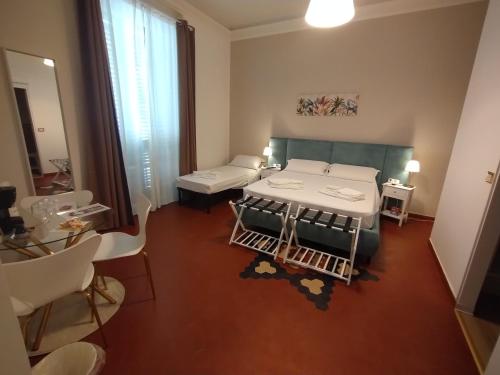 a room with a bed and a table and chairs at Le Camere di Suleima in Messina
