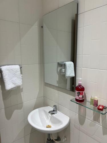 a white bathroom with a sink and a mirror at Aparta hotel brisas Del tayrona in Santa Marta