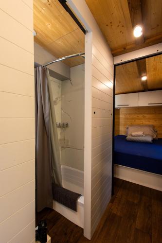a bedroom in a tiny house with a shower at Espace des Grands-Ducs - Domaine de Lacs et de forêt in Sacré-Coeur-Saguenay