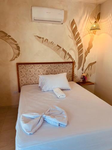a bedroom with a bed with a bow on it at Aparta hotel brisas Del tayrona in Santa Marta