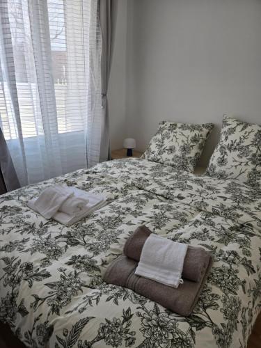 a bed with a blanket and two towels on it at Séjour Eau Vive Proche commerces et Metro in Créteil