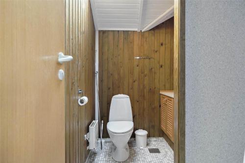 a small bathroom with a toilet and wooden walls at 17701-Follenslev-Middelvej-2 in Føllenslev
