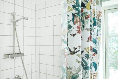 a shower curtain in a bathroom with white tiles at 13301-1-Asnaes-Lindevej-5 in Asnæs
