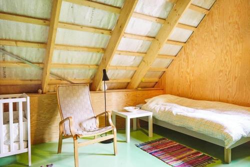 a bedroom with a bed and a chair and a lamp at 13301-1-Asnaes-Lindevej-5 in Asnæs