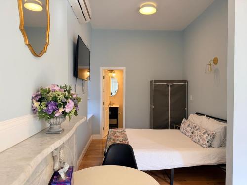 a small room with a bed and flowers on the wall at Bright Private Apartment in University City Walk to Drexel&Near UPenn in Philadelphia