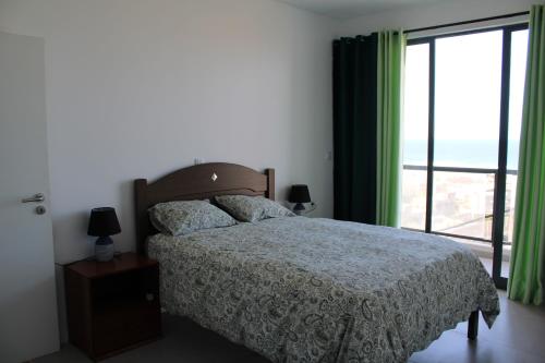 a bedroom with a bed and a large window at Casa Thisolore in Ponta do Sol