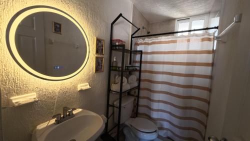 a bathroom with a sink and a mirror and a toilet at Departamento Belinda in Ixtapa