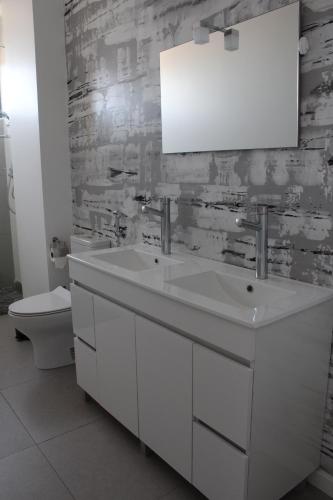 a bathroom with a white sink and a toilet at Casa Thisolore in Ponta do Sol