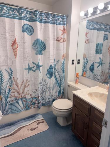 a bathroom with a toilet and a shower curtain at Vermont By The Sea in Cape May