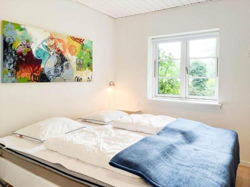a bedroom with a bed with a painting on the wall at 14235-Grevinge-Askebjerggardsvej-20 in Grevinge