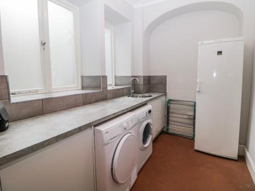 a kitchen with a washing machine and a sink at Gulliver's in Matlock