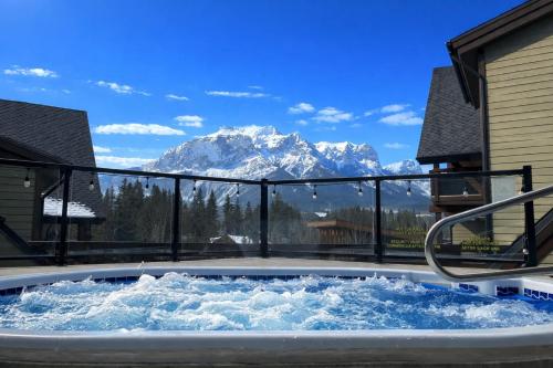 a hot tub with a view of a mountain at Tranquility at Rundle Cliffs Lodge in Canmore