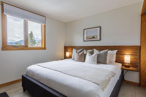a bedroom with a large bed and a window at Morningside - Pet Friendly Stunning Mtn Views in Canmore
