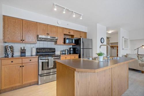 a kitchen with wooden cabinets and a counter top at Morningside - Pet Friendly Stunning Mtn Views in Canmore