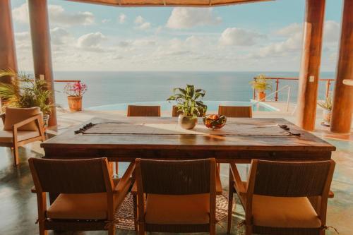 a dining room with a table and chairs and the ocean at Private Cliffside Villa with Infinity Pool in Sayulita