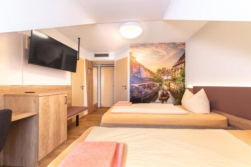 a hotel room with two beds and a tv at Hotel Restaurant Fallerhof in Bad Krozingen