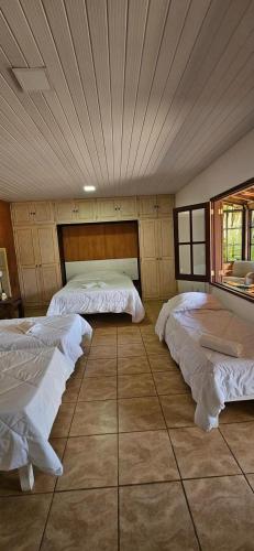 a bedroom with two beds in a room with a ceiling at Hotel Boutique Pé Da Tartaruga in Teresópolis