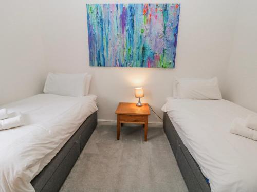 two twin beds in a room with a table at Abraham in Matlock